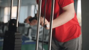 Man in gym doing weight exercise 4k video. Male training arms triceps muscles using cable machine for body mass. Workout bodybuilding sport concept.