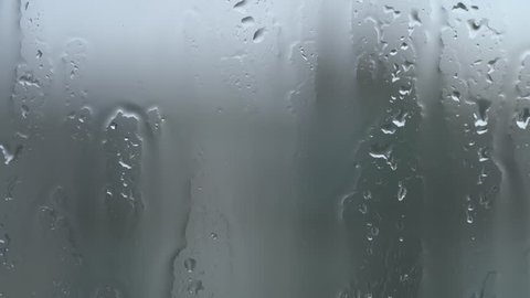 Raindrops on glass of window. 4k video footage.