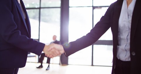 4K Focus on hands of two businesswomen meeting and shaking hands in office lobby