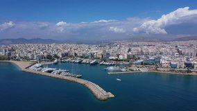 Aerial drone panoramic video of iconic port of Marina Zeas or Pasalimani with yachts and sail boats docked and beautiful blue sky - clouds, port of Piraeus, Attica, Greece