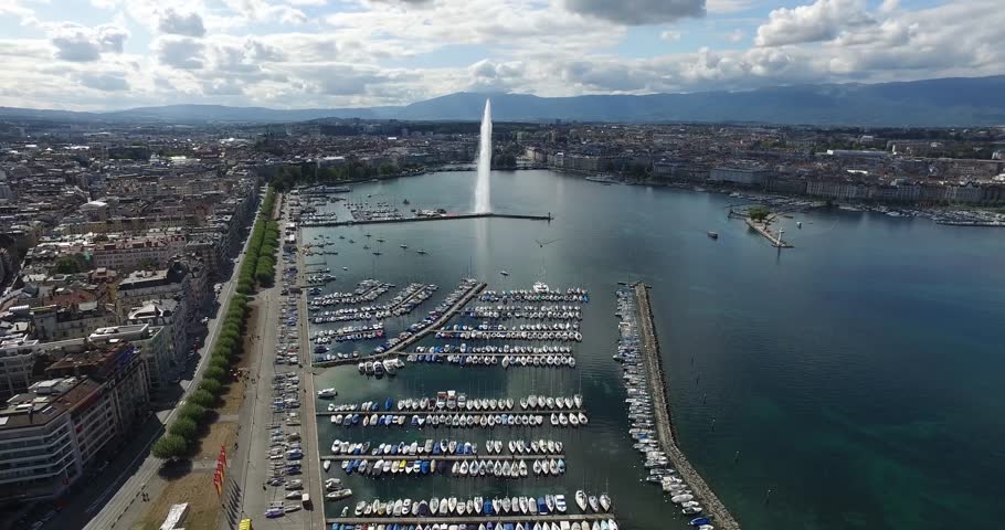Daylight aerial view of Lake Geneva, centered on famous water fountain, with city in the background. Sunny summer day, with sparse clouds - great feel! [Geneva, Switzerland]