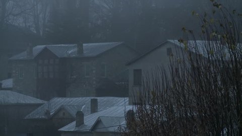 medium shoot of a traditional village into a blizzard
