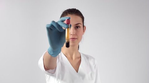 Young attractive female Caucasian doctor-cosmetologist demonstrates blood collection tube with centrifuged blood - separated platelet rich plasma
