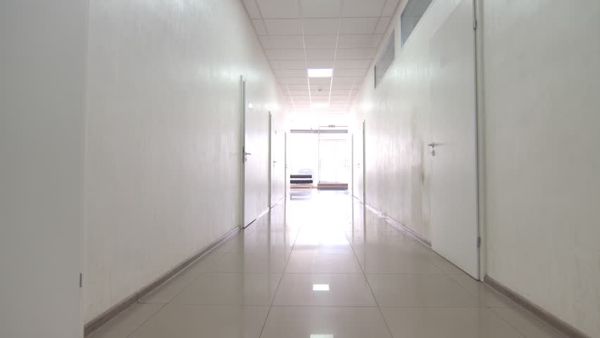 Doctor with red organ trafficking container going along the corridor towards the exit from the hospital. Royalty-Free Stock Footage #1027607846