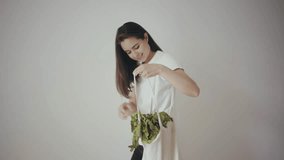 Happy smiling brunette girl with a tote blank cotton bag for shopping with fresh green vegetables inside. Reusable canvas grocery bag, no plastic, for sustainable shopping. Save the planet - Powered by Shutterstock - Get 15% off with code: PIKWIZARD15
