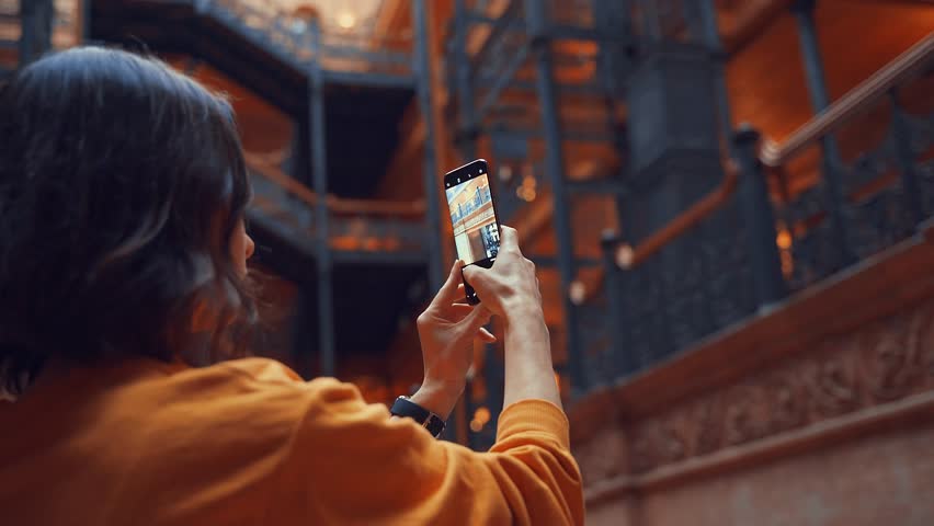 Young tourist takes photo in a building