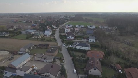 Aerial view of a small European village in Poland. A small village in the suburbs of Warsaw. Top view over the houses surrounded by green lawns. Drone shot 4k. Video format RAW.