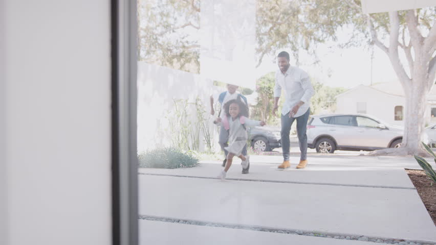 African American Father Bringing Excited Children Back Home From School Opens Front Door Of House