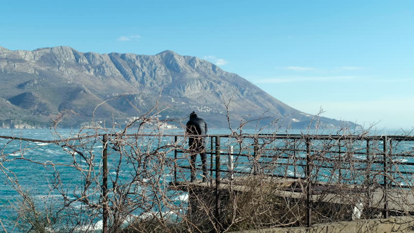 Man in black clothes  Standing near In Bad and Storm Weather, Budva, Montenegro
