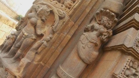 apsara dancer spirit and naga deity snake bas-reliefs on wall of ancient hindu temple Rajarani circular movement of camera Bhubaneswar Orissa