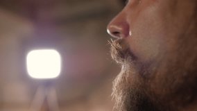close-up of a man's face with a mustache and beard drinking lager beer from a bottle. 4k video