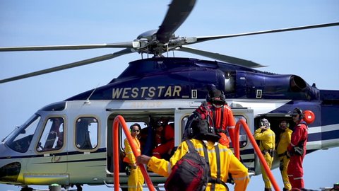 KELANTAN, MALAYSIA - APRIL 10 2019 : A Helicopter Landing Officer (HLO) managing offshore workers and their luggage loading inside commercial helicopter Agusta Westland AW 139.