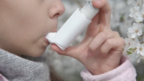 Asthma. Pollen allergy. A child with an inhaler.
