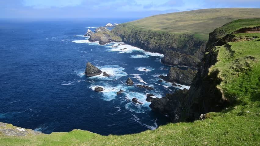 Spectacular coastline with sea cliffs and stacks, home to breeding sea birds at Hermaness, Unst, Shetland Islands, Scotland, UK Royalty-Free Stock Footage #1027639688