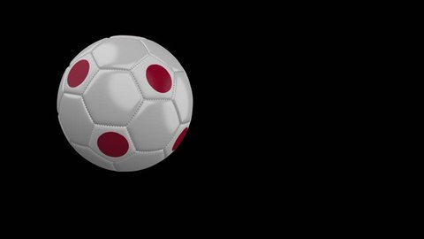 Soccer ball with the flag of Japan flies past the camera, slow motion, 4k footage with alpha channel
