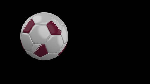 Soccer ball with the flag of Qatar flies past the camera, slow motion, 4k footage with alpha channel