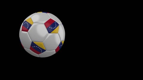 Soccer ball with the flag of Venezuela flies past the camera, slow motion, 4k footage with alpha channel