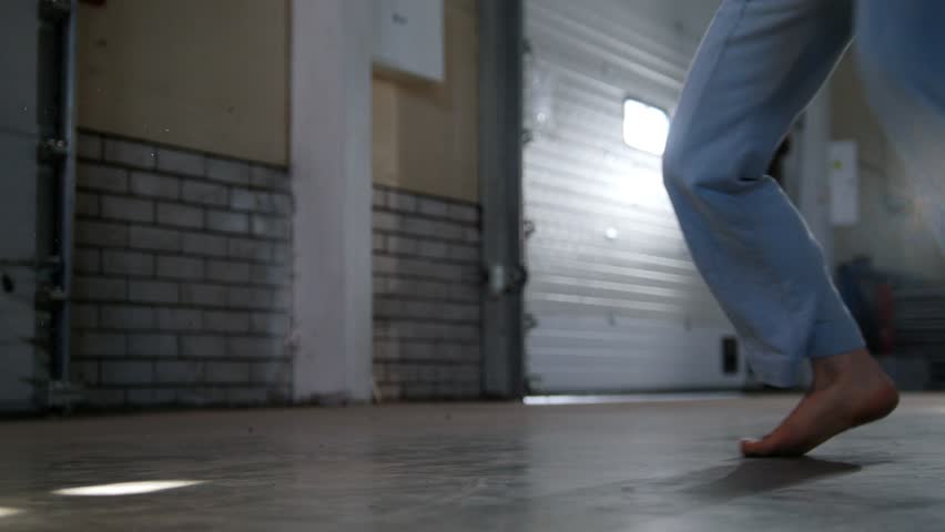 An athletic man training his skills. Performing capoeira elements