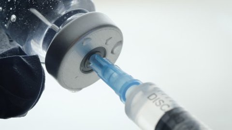 Extreme closeup of filling a syringe from a vaccine bottle. Mandatory vaccinations are currently a hotly debated topic with anti-vaxxers. Causing global outbreaks of preventable diseases like measles.