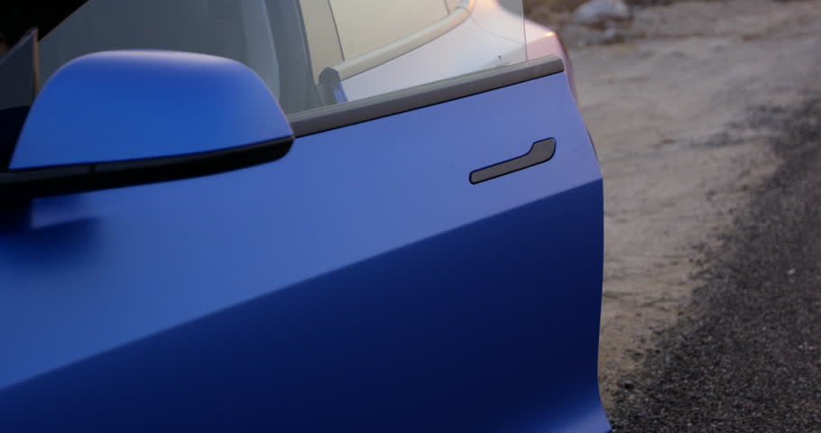 Stylish blue sports car door closing on the side of the road