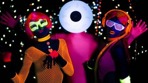  fantastic video of 3 sexy cyber glow ravers filmed in fluorescent clothing under UV black light. 2 cool women and a guy with a circular head