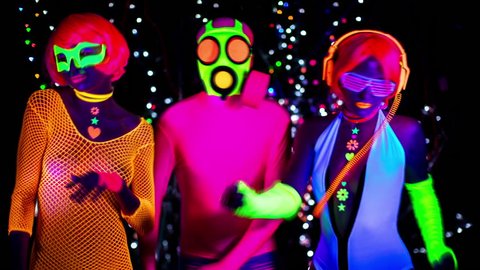 fantastic video of 3 sexy cyber glow ravers filmed in fluorescent clothing under UV black light. 2 cool women and a guy in a gasmask.