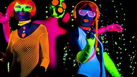 fantastic video of 3 sexy cyber glow ravers filmed in fluorescent clothing under UV black light. 2 cool women and a guy in a gasmask.