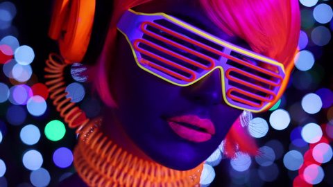 sexy cyber raver woman filmed in fluorescent clothing under UV black light