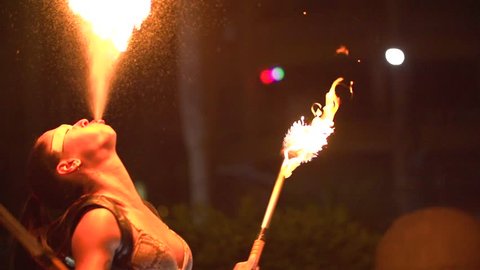 woman spiting fire in a fire show at night - slow motion
