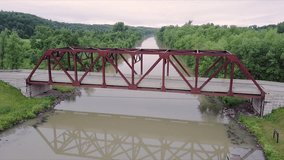 Drone clip descending showing a steel bridge with a car driving over