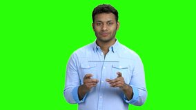 Young man using glass digital tablet. Handsome Indian man working on futuristic transparent tablet pc. Green screen background. - Powered by Shutterstock - Get 15% off with code: PIKWIZARD15