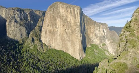 YOSEMITE NATIONAL PARK, CA, USA. El Capitan looming high above the valley. Aerial 4K view of the giant rock formation.