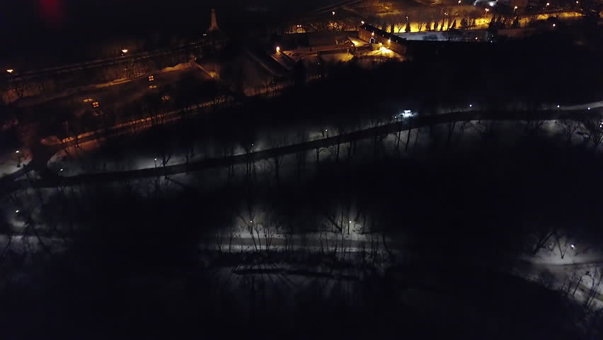 Cinematic aerial - drone moving forwards footage with Jacques Cartier bridge, city lights, downtown and a ship in the background in Montreal, Quebec, Canada during winter season - night time.