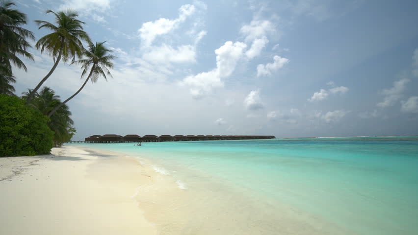Idyllic tropical beach in the Maldives, ocean bungalow huts in the distance | Shutterstock HD Video #1027683383