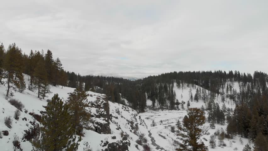 Drone shot along a snow-covered rocky cliff near the Palouse in Eastern Washington