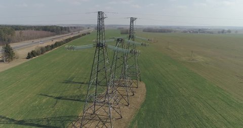 Power line, industrial view from a height on the line of electric transmissions in field, steel tower with wires and communication of electric power supply.