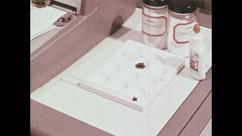 1960s: UNITED STATES: monomer testing in spectrometer. Scientist places substance in spectrometer.