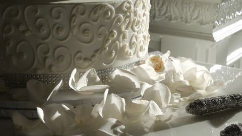 Close tilt up on white wedding cake sun shining on, videoclip de stoc