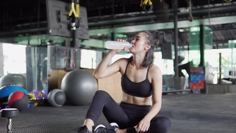 Asian women are exercising in the gym drinking water. Slow motion