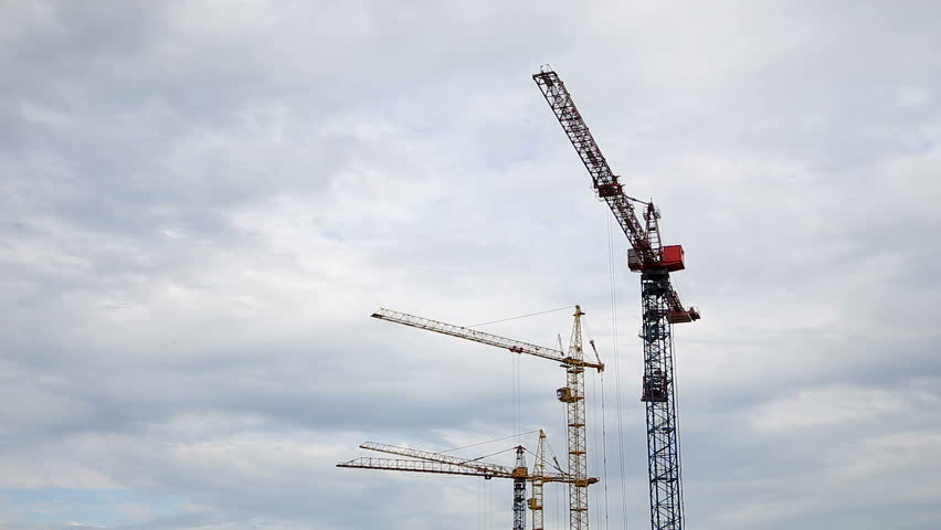 Cranes Working on Construction Site Under Grey Cloudy Sky on a Rainy Day Timelapse Royalty-Free Stock Footage #1027714562