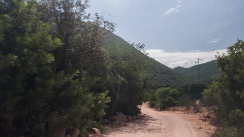 POV shot from a camera attached to the front of an off road vehicle driving through beautiful trails and paths in sardinia
