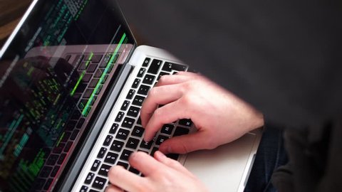 Anonymous Hooded Hacker Programming in Computer Console Breaking Password