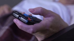 Close up of old womans hand with TV remote controller switching channels, relax - Powered by Shutterstock - Get 15% off with code: PIKWIZARD15