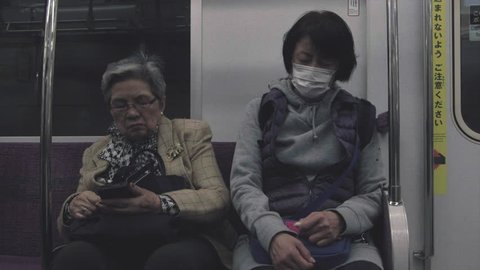 TOKYO, JAPAN - APRIL 14TH, 2019. Commuters commuting in a Japan Railway Yamanote train. Cinematic color graded.