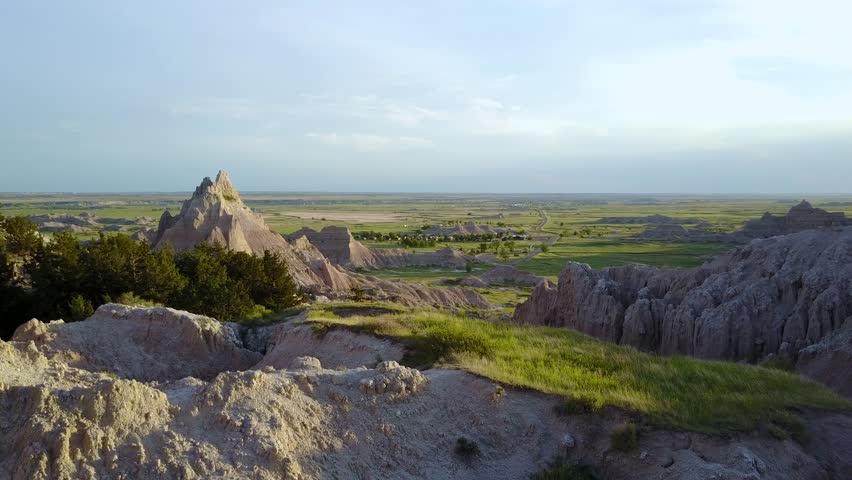 Green grass and spires on a sunny day at Badlands National Park in the South Dakota desert