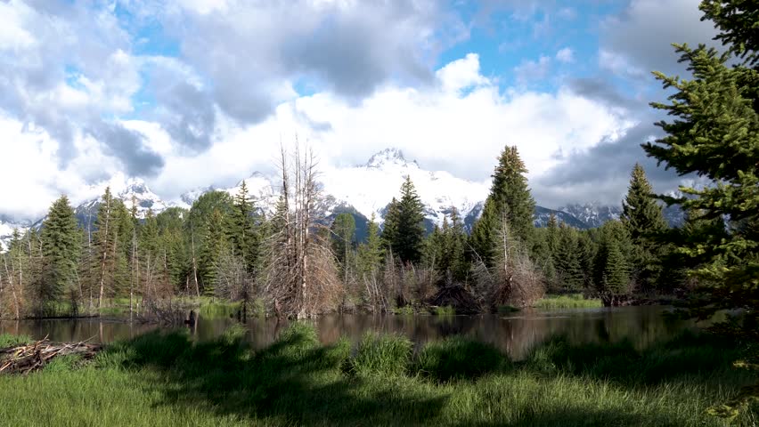 Slow right pan of the Snake River in Grand Tetons National Park, Wyoming with snow capped peaks