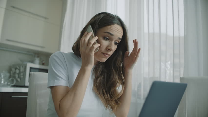 Angry woman call phone at home. Annoyed person talking mobile phone at kitchen. Upset woman using cellphone at home kitchen. Businesswoman arguing in phone conversation | Shutterstock HD Video #1027757729