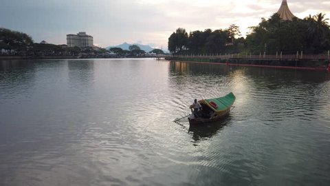 KUCHING, SARAWAK - APRIL 2019. cinematic shot of boats carrying passenger across sarawak river in Kuching Waterfront. 