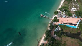 Bird eye aerial drone footage flying over a peer on a beach in Cambodia.