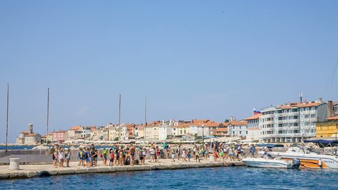 PIRAN, SLOVENIA - 7. AUGUST 2018 Many people are standing on the pier. Perhaps they are waiting to go on a boat.